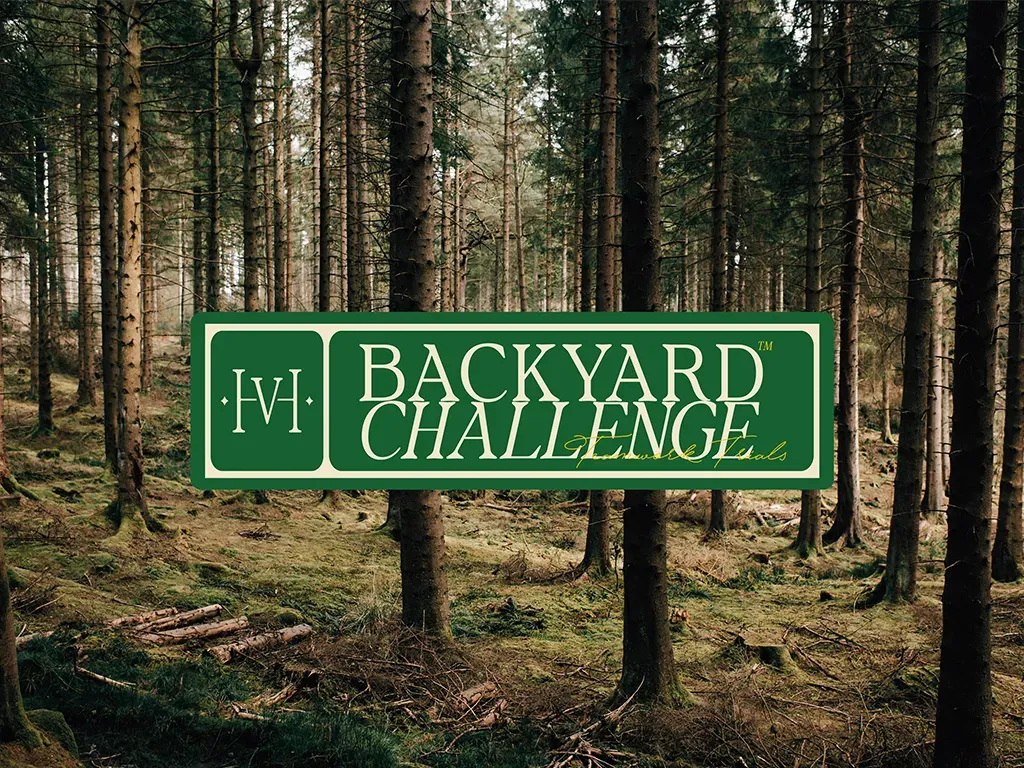Skylt med texten Backyard Challenge mot en granskog